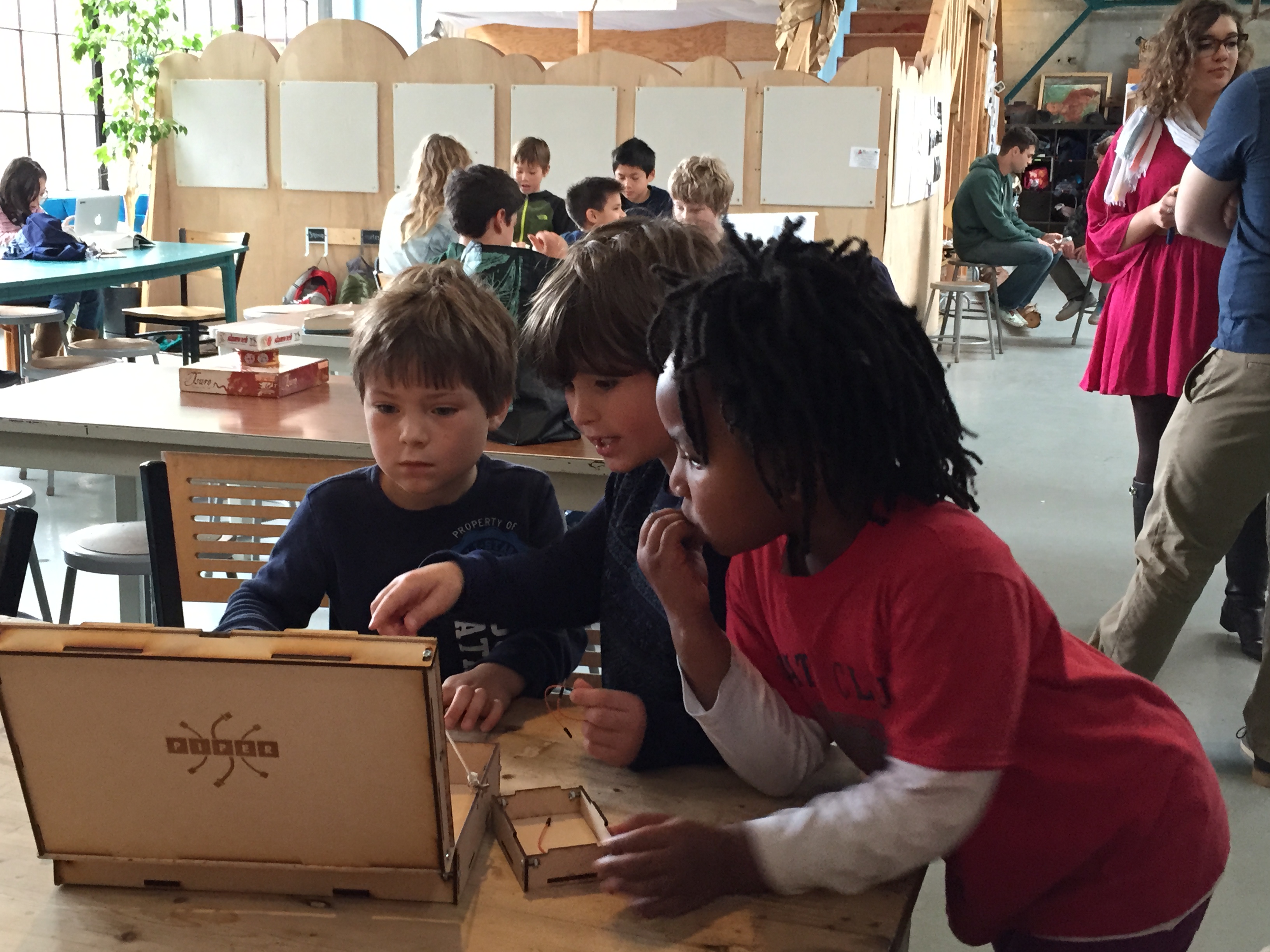 Kids testing a wood prototype of the Piper Computer Kit