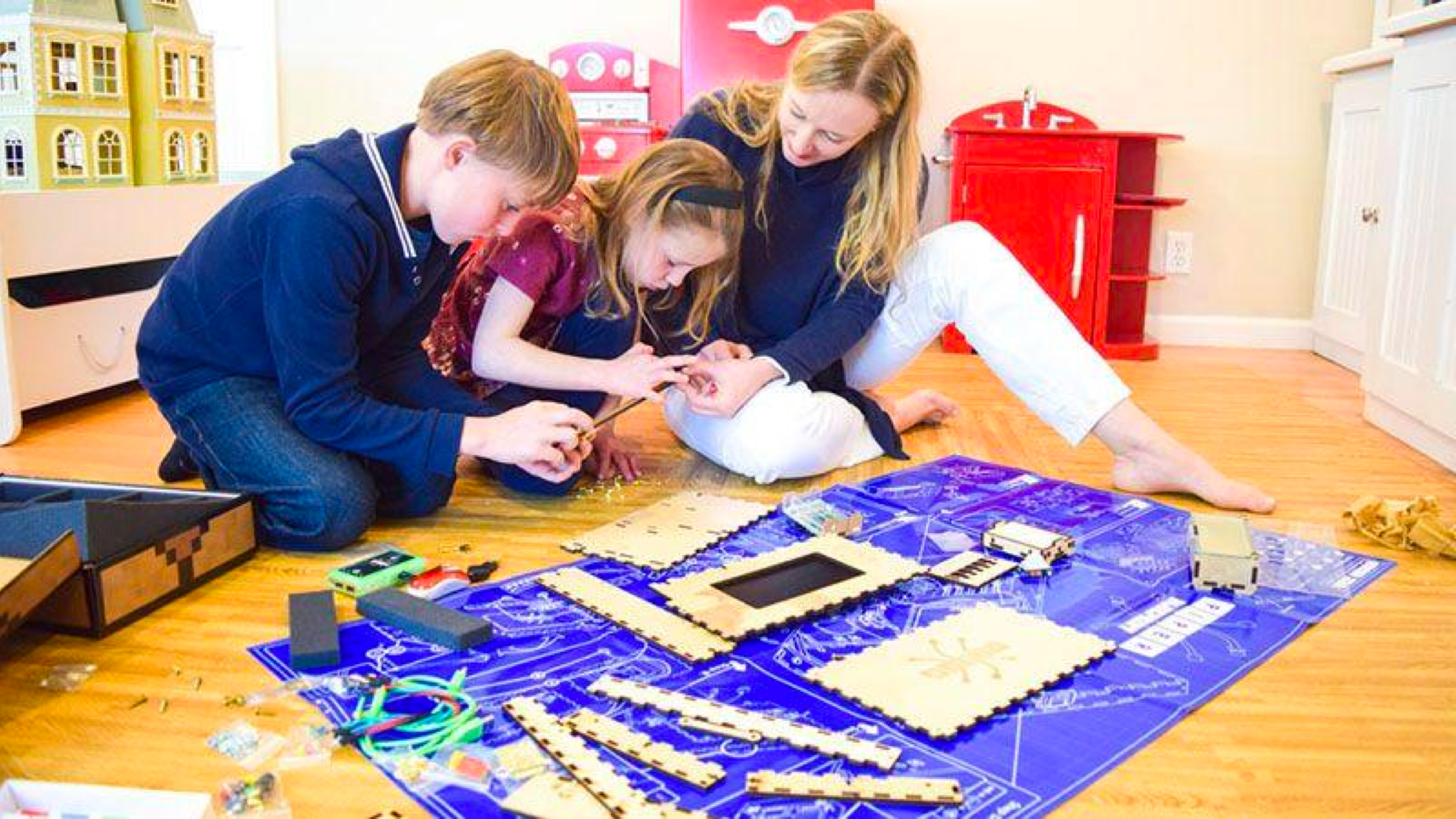A family building a Piper Computer Kit together on their living room floor