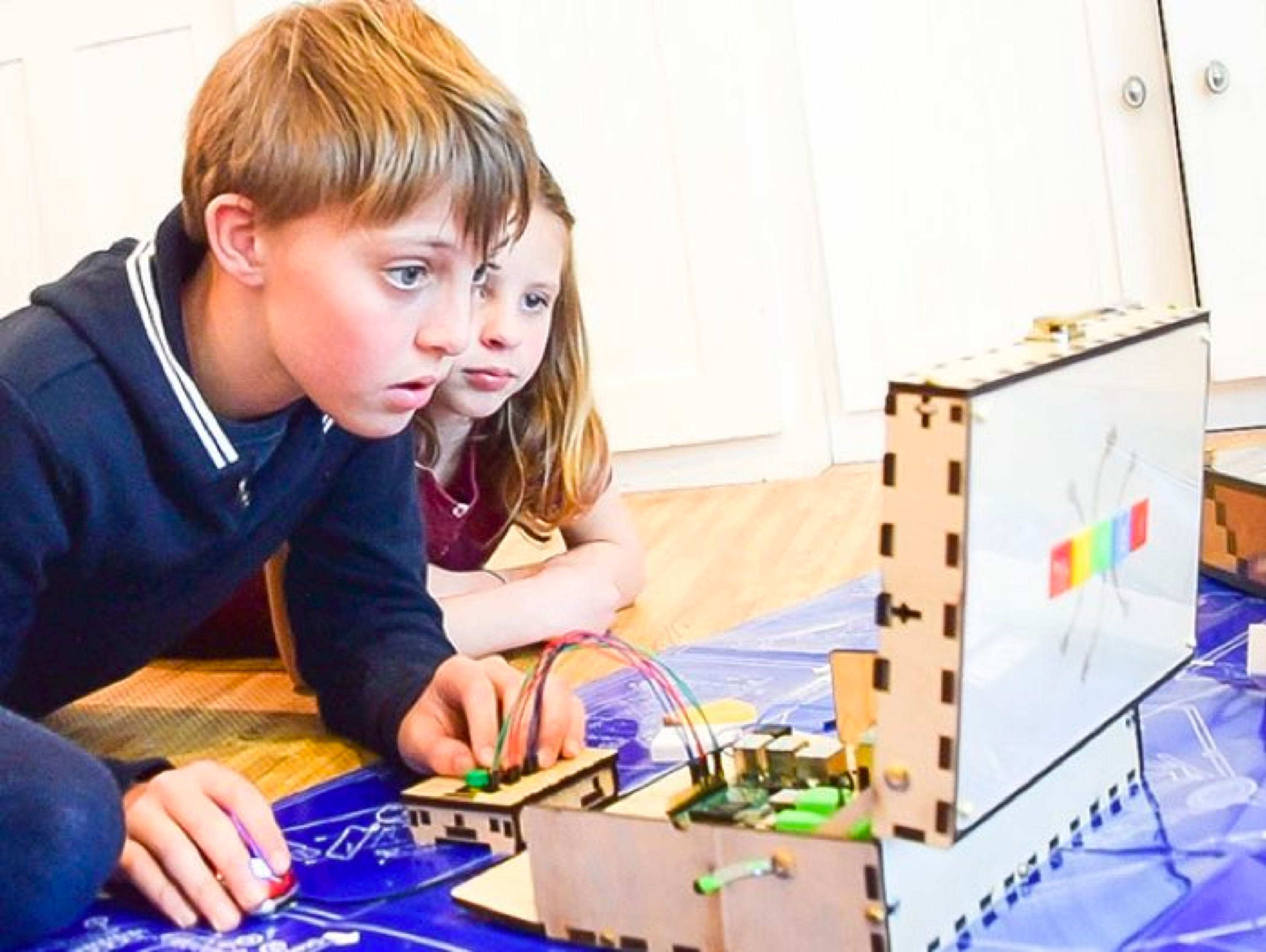 Two kids intently testing their assembled Piper Computer Kit